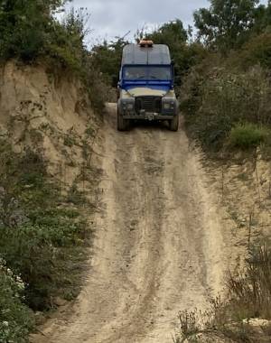 Photo of me driving a 4x4 vehicle down a steep, muddy hill